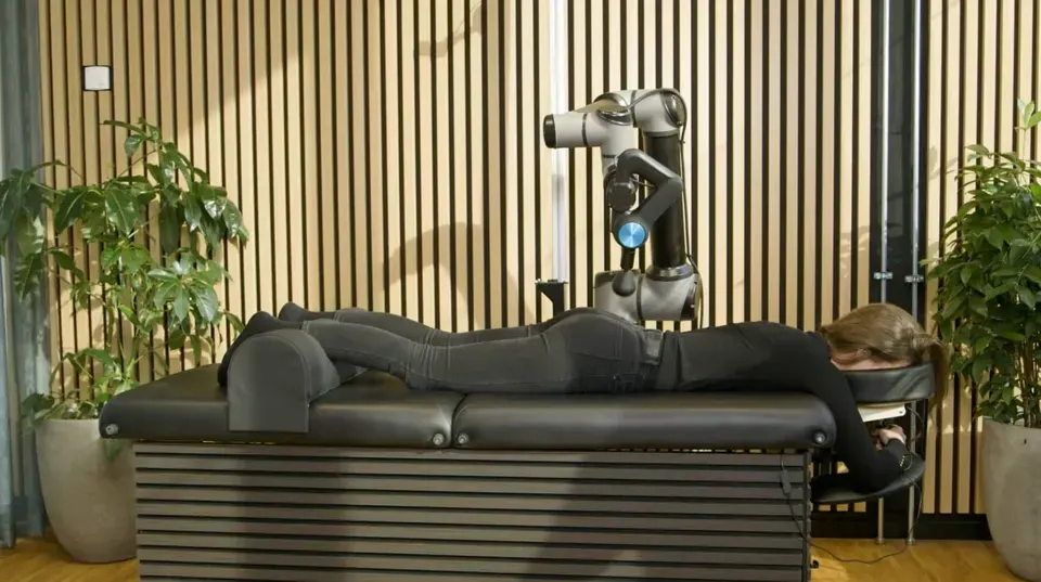 A member lying fully clothed on the Self bed during a percussion session